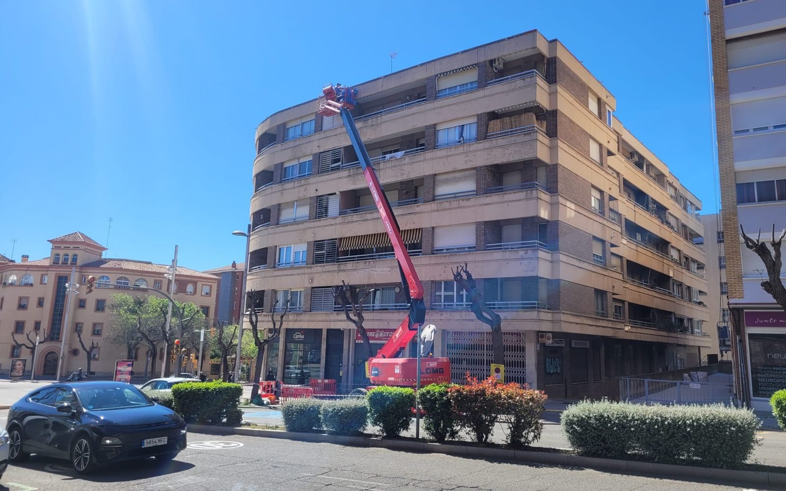 Plataforma elevadora trabajando en la fachada de un edificio de viviendas